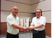 左が筆者、右が福島大学の柴崎直明教授。分科会場で謝意と連帯を込めて握手。.jpg